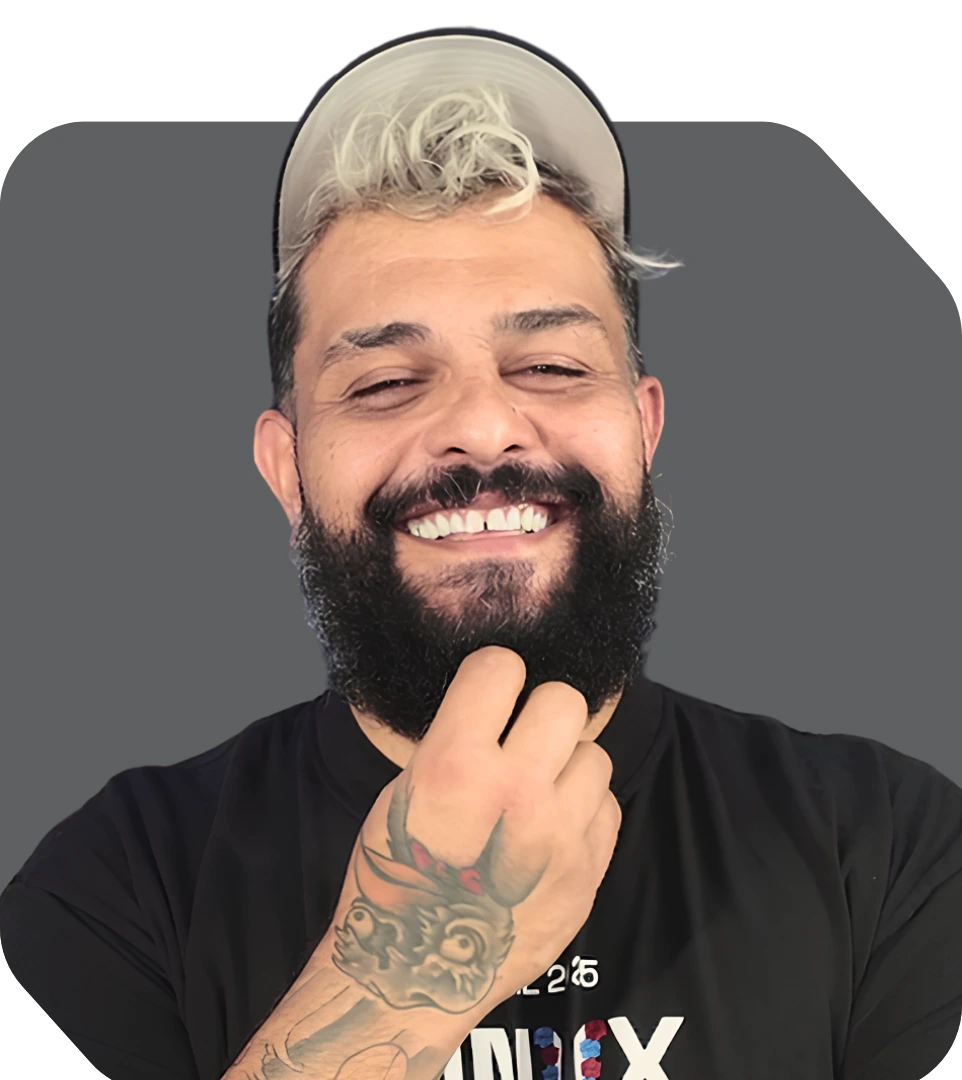 Instrutor de vários treinamentos, Jeferson é um homem de barba, boné e cabelo descolorido sorrindo com a mão no queixo.